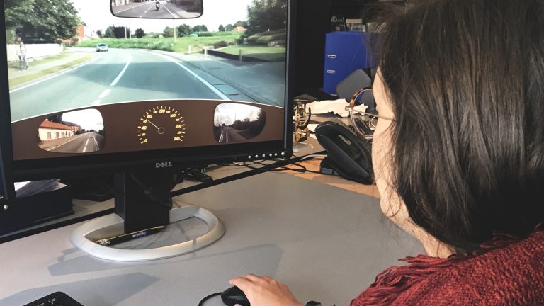 Iemand voert de risicoperceptietest uit tijdens het praktisch rijexamen.
