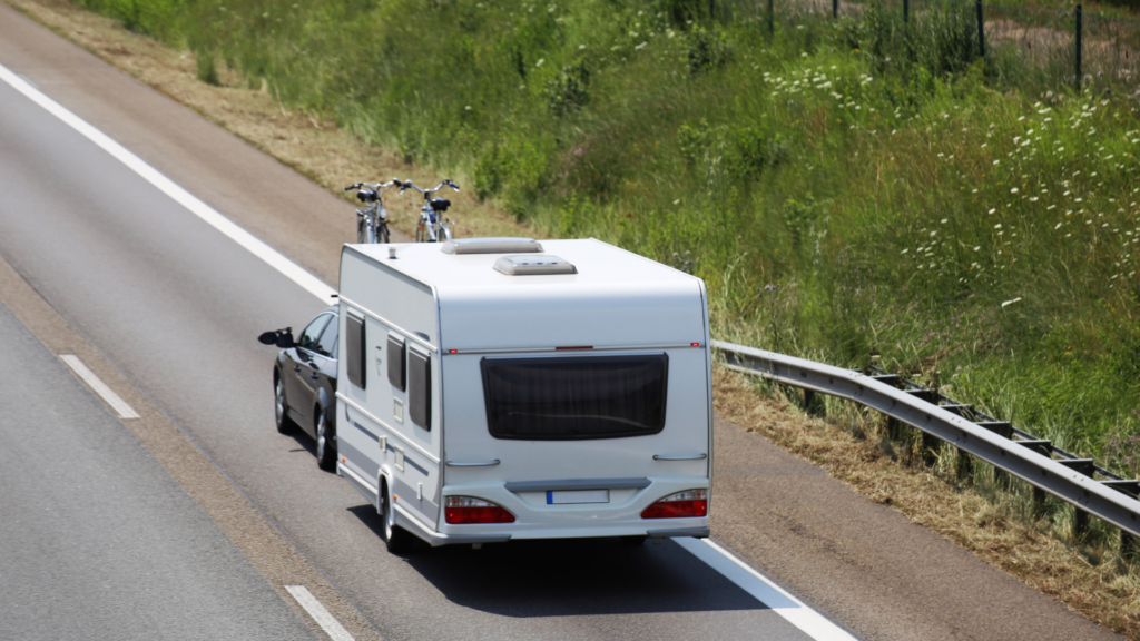 Caravan-trekken_-zwarte-auto-met-2-fietsen-op-het-dak-die-een-caravan-trekt