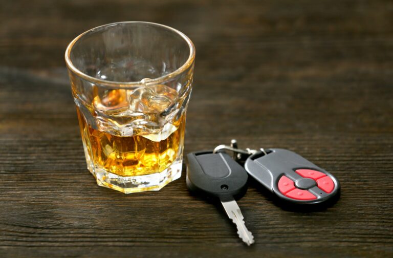 een glas alcohol naast een autosleutel
