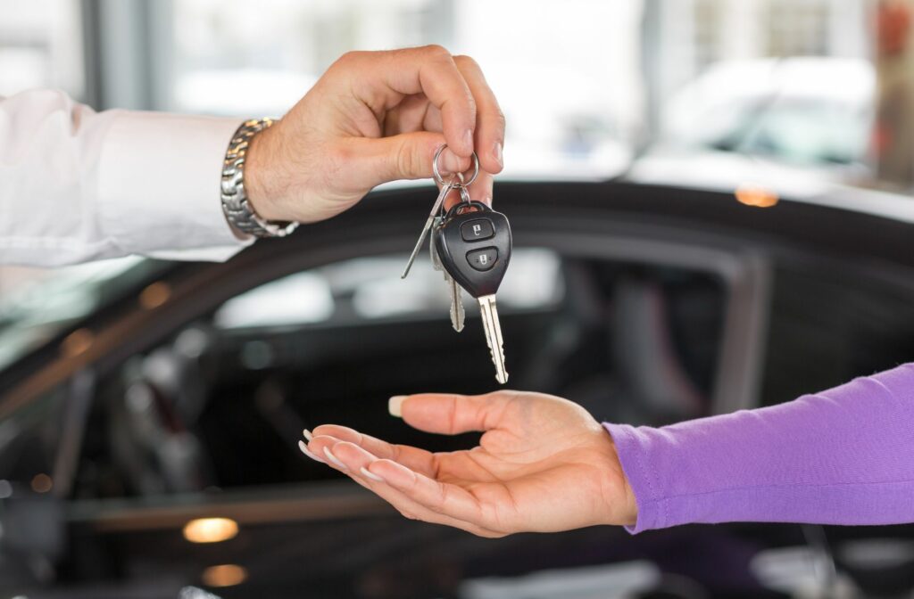 iemand overhandingt de sleutel van een auto