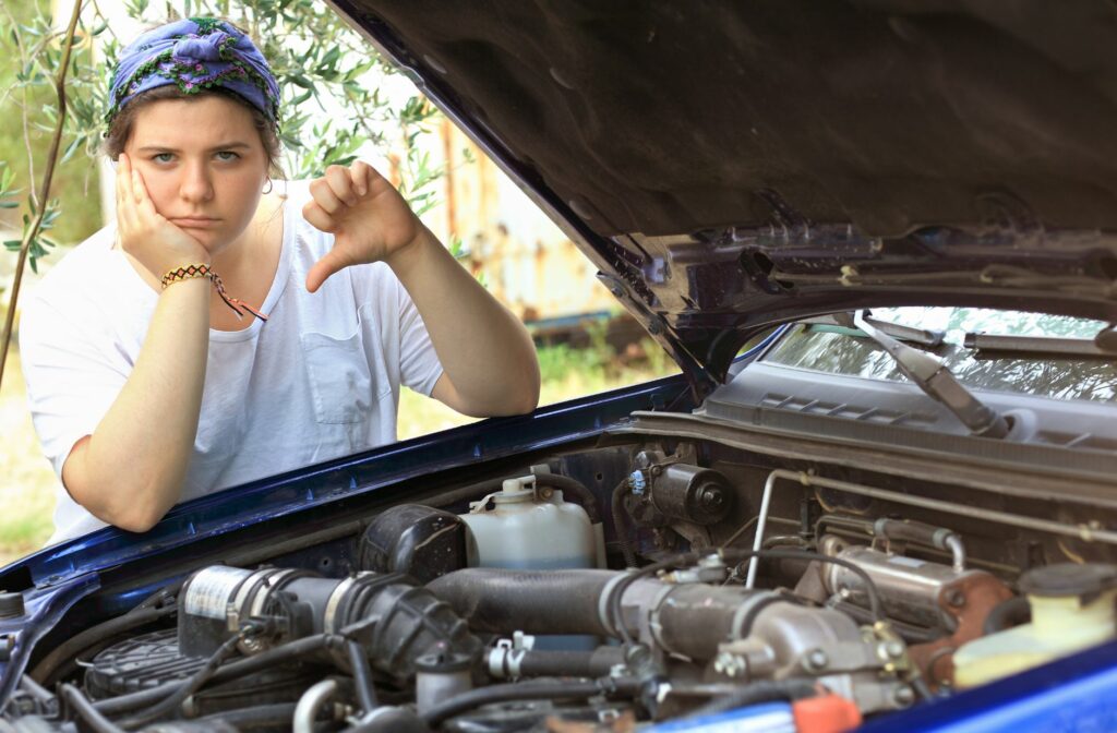 Mevrouw men haar duim omlaag naast haar kapotte auto
