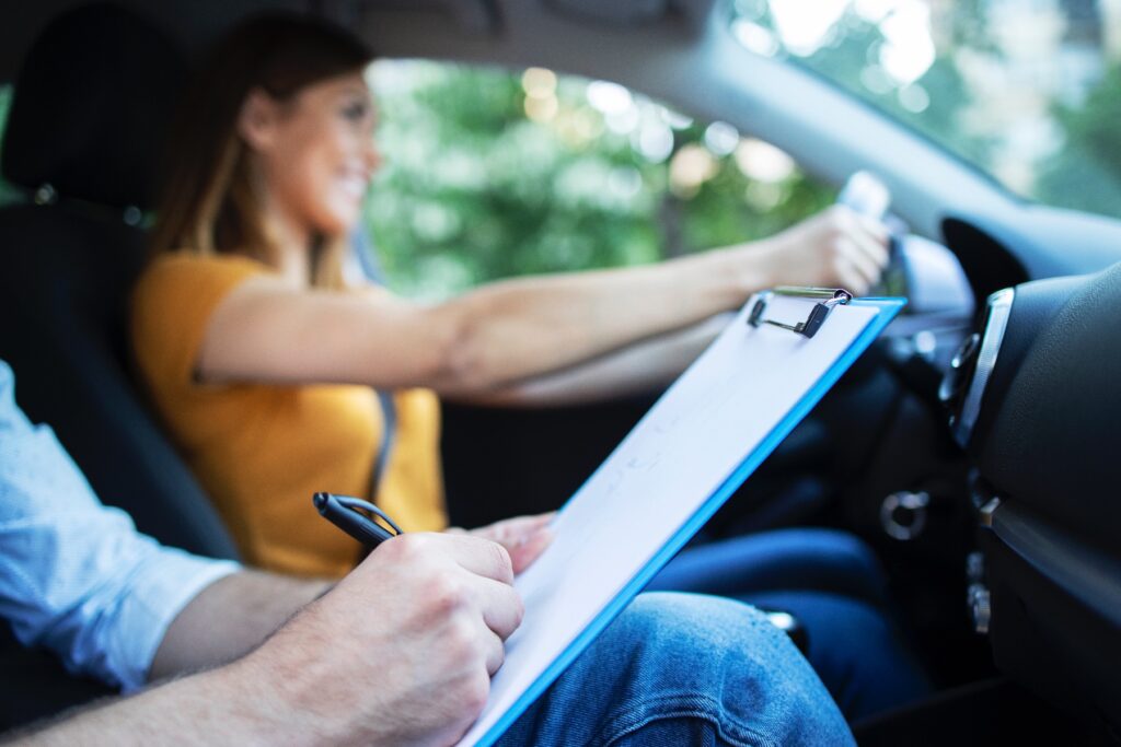 Vrouw achter het stuur en examinator naast haar