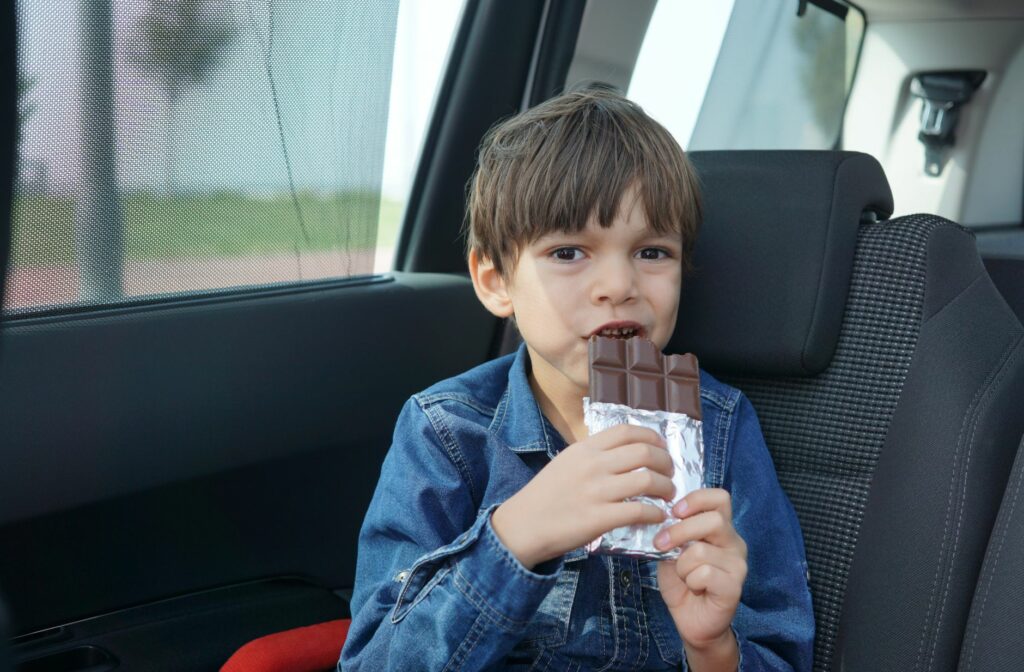 Kind dat chocolade eet in de auto