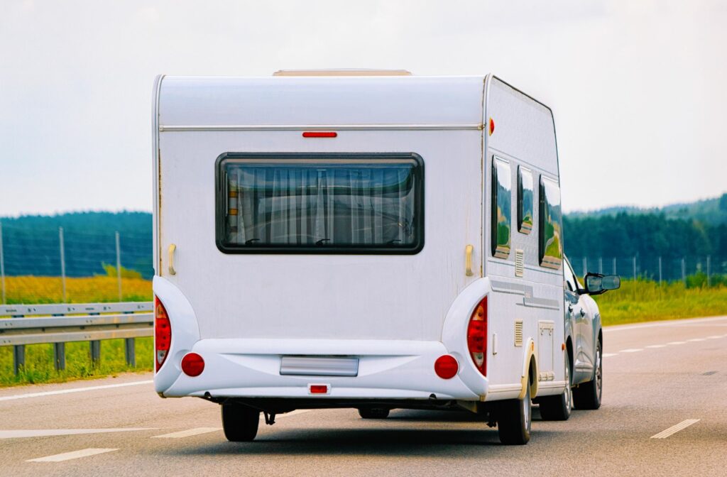 Caravan achter een auto op de autosnelweg waar andere snelheidslimieten voor gelden