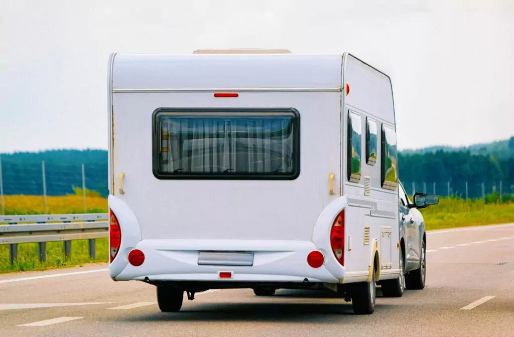 Caravan achter een auto op de autosnelweg waar andere snelheidslimieten voor gelden