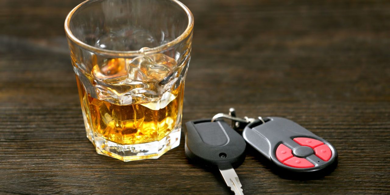 een glas alcohol naast een autosleutel