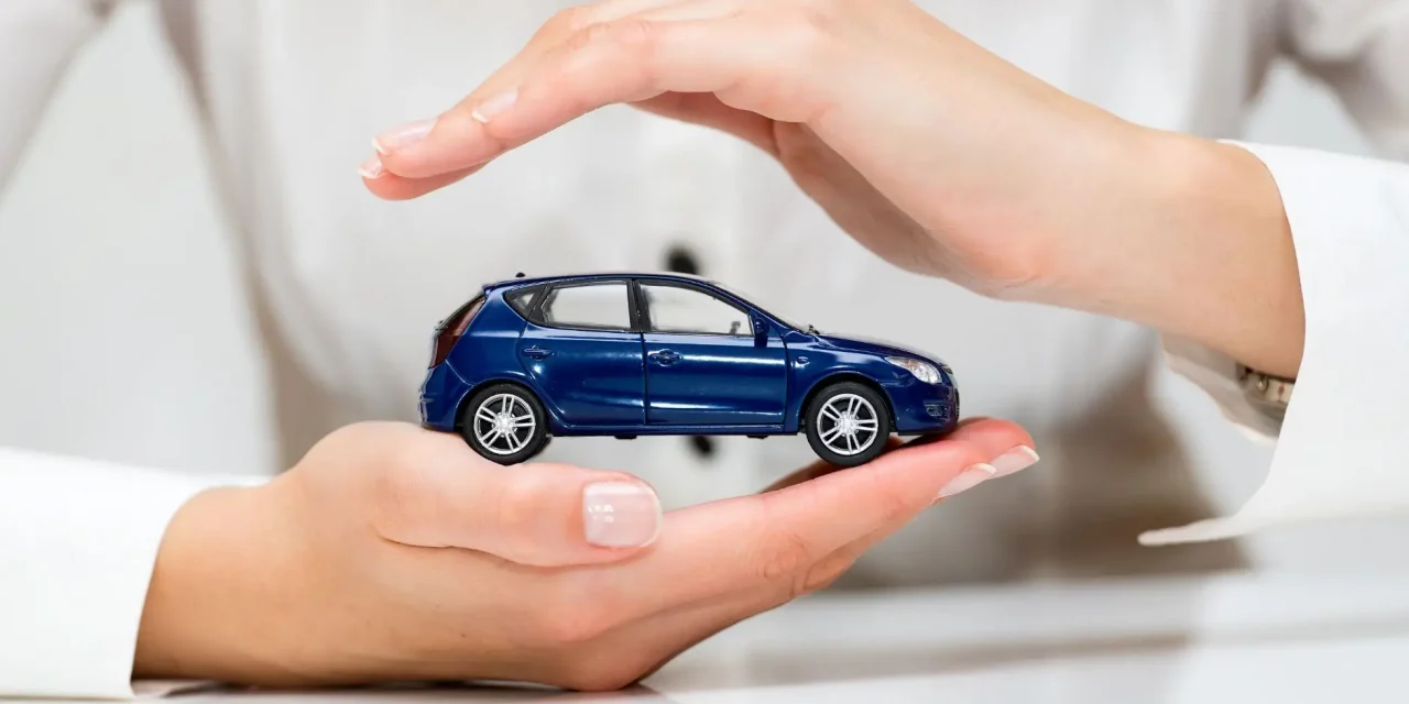 een speelgoedauto wordt tussen 2 handen gehouden om aan te duiden dat het om de verzekeringen voor een bedrijfsauto gaat