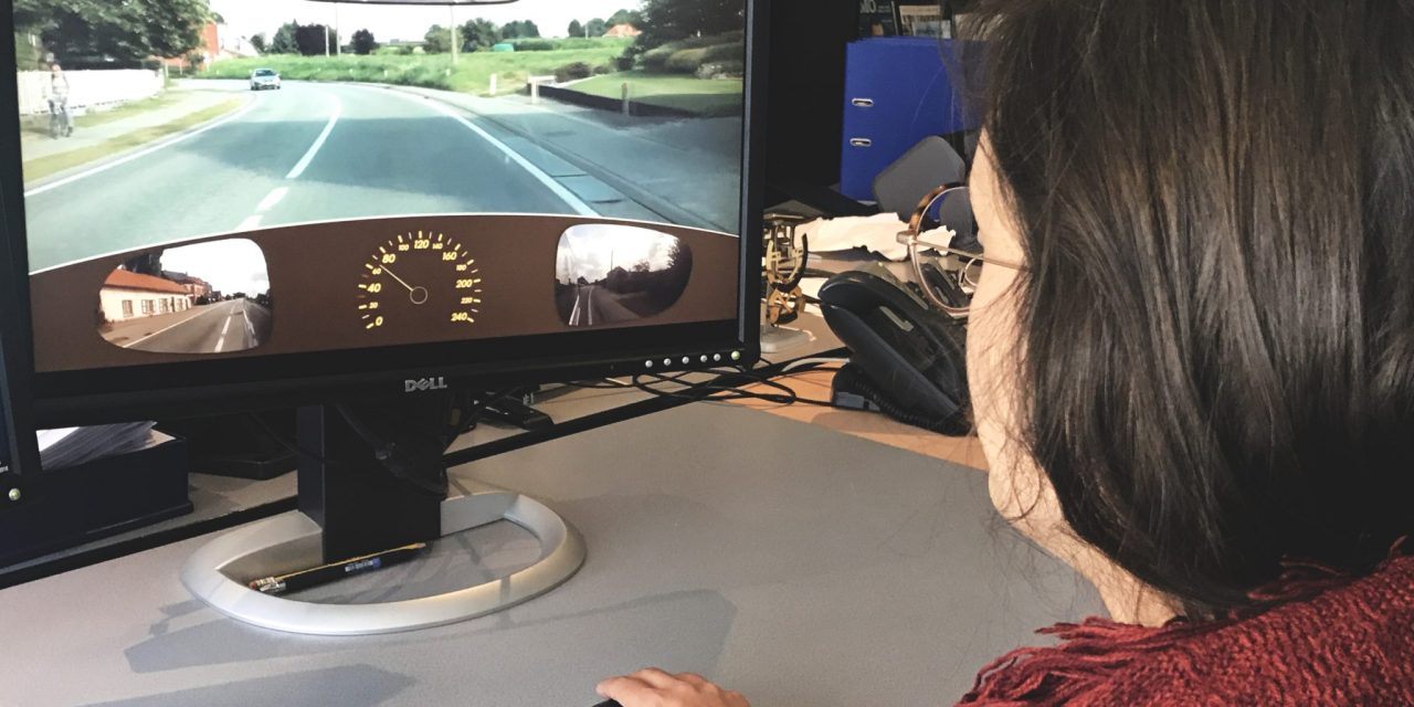 Iemand voert de risicoperceptietest uit tijdens het praktisch rijexamen.